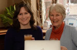 Two women book editors smiling and holding cups of tea