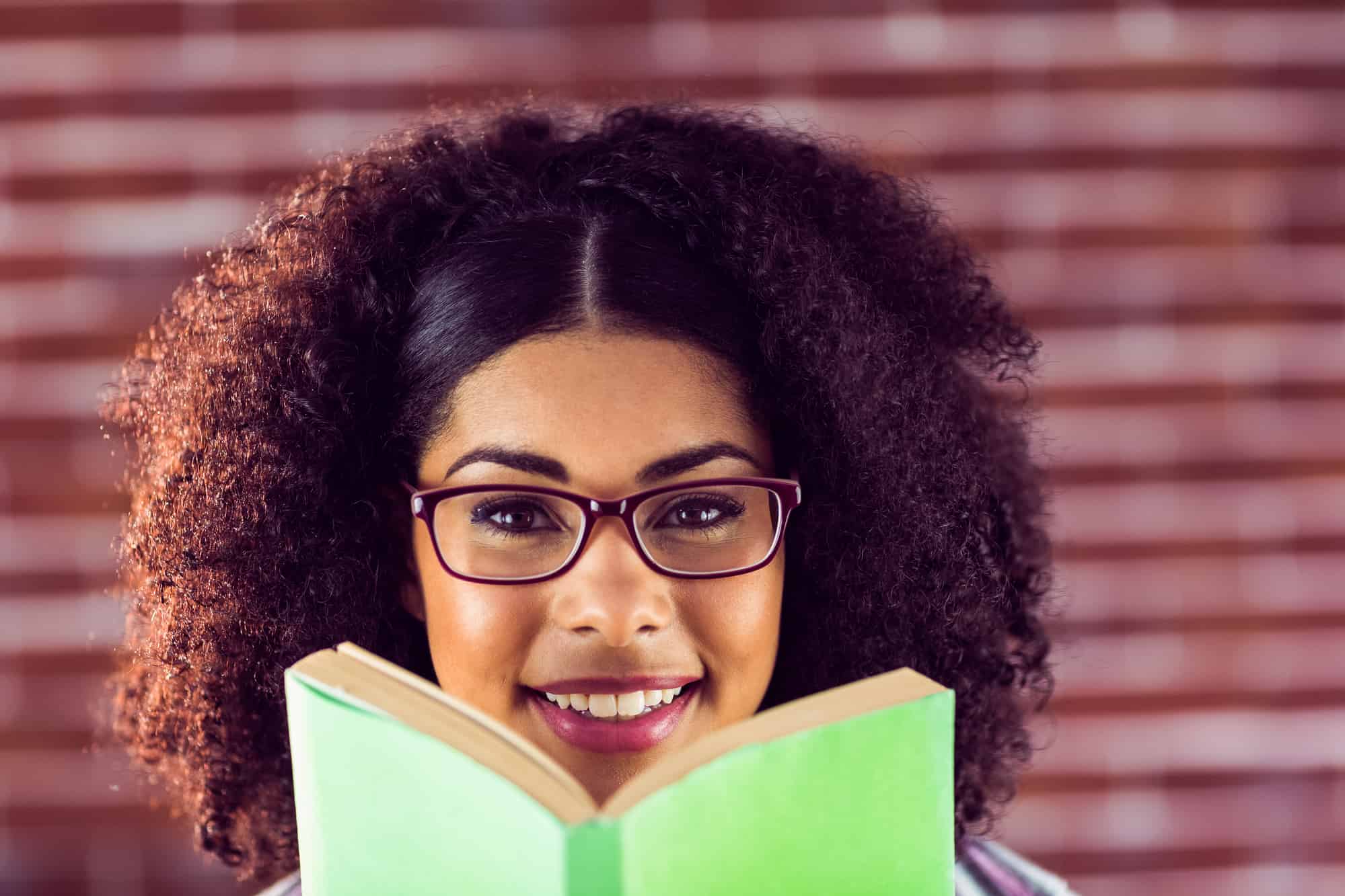 a young woman holding a book and smiling