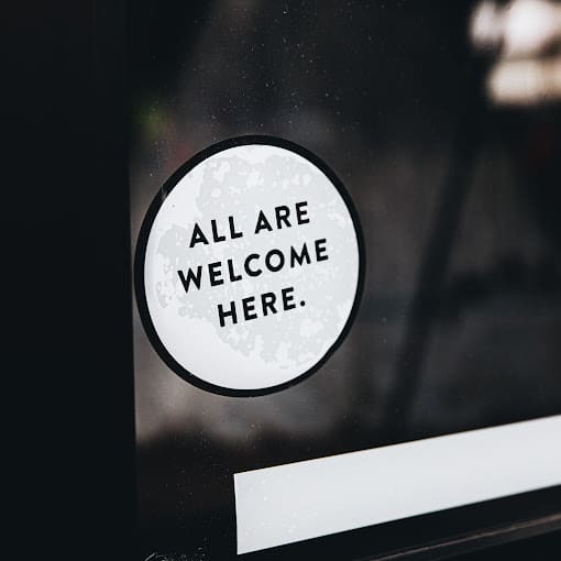 window decal reading "all are welcome here"