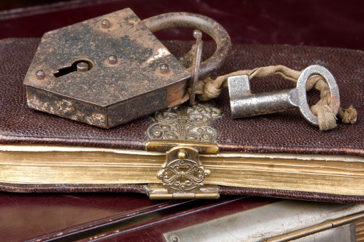 Padlock and key on very old locked books